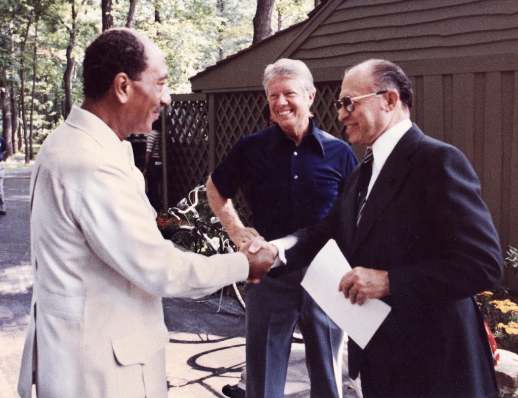 Former Egyptian President Anwar Sadat (L) shakes hands with former Israeli Prime Minister Menachem Begin, as former U.S. President Jimmy Carter looks on Sept. 6,1978 at Camp David, the U.S. presidential retreat in Maryland. Egypt began peace initiatives with Israel in late 1977, when Sadat visited Jerusalem. A year later, with the help of Carter, terms of peace between Egypt and Israel were negotiated at Camp David. KARL SCHUMACHER/AFP/Getty Images