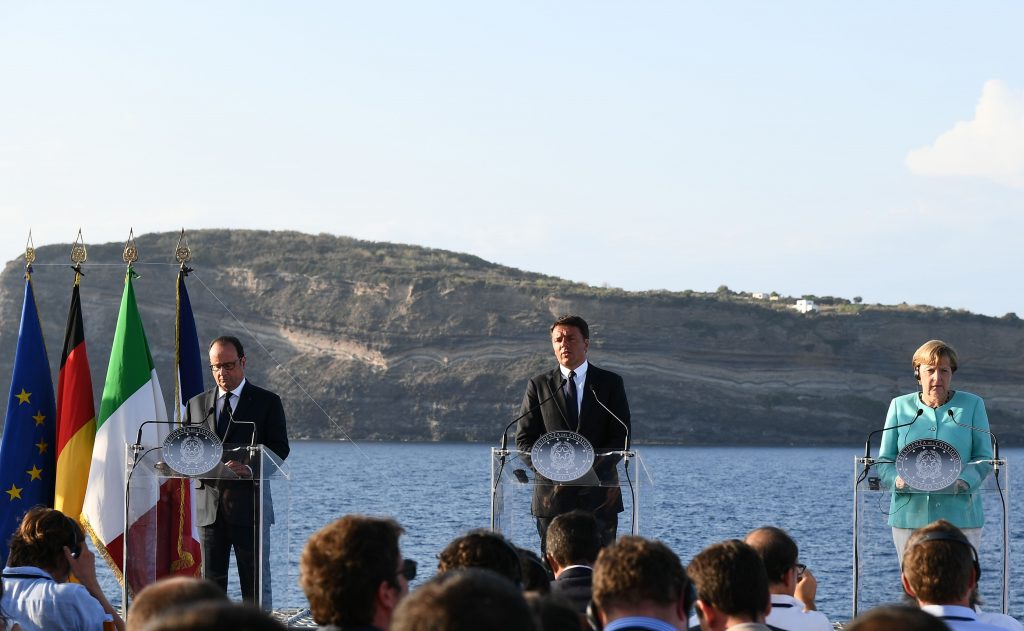Italian Prime Minister Matteo Renzi, flanked by German Chancellor Angela Merkel (R) and French President Francois Hollande (L), gestures as he delivers a speech on Aug. 22, 2016 during a joint press conference held aboard the Garibaldi aircraft carrier on the harbor of the Italian island Ventotene. VINCENZO PINTO/AFP/Getty Images