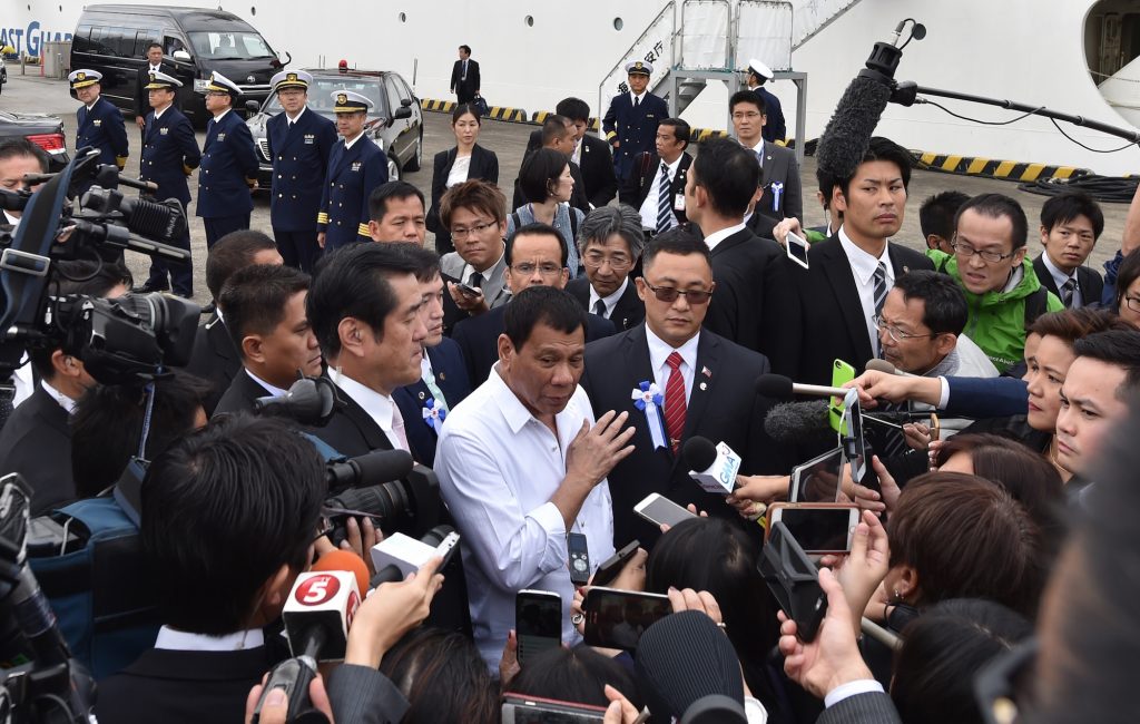 Philippine President Rodrigo Duterte (C) is surrounded by the media as he answers questions following his inspection of Japan's coast guard drills in Yokohama on October 27, 2016. Duterte observed coast guard drills on the final day of a visit to Japan during which tensions in the South China Sea have been a key topic. / AFP / KAZUHIRO NOGI (Photo credit should read KAZUHIRO NOGI/AFP/Getty Images)
